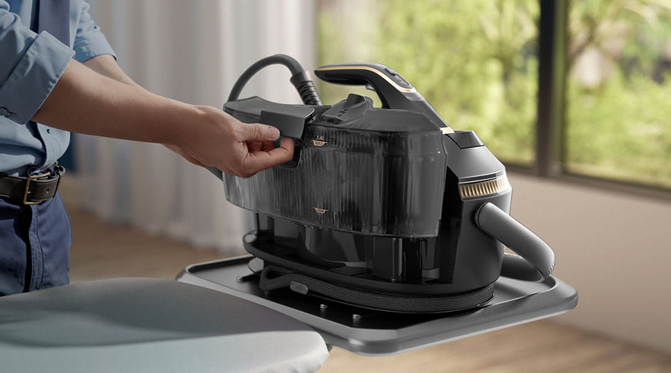 Žehliaci systém Philips 8000 Series PSG8200/80 sivý Muž odníma nádržku na vodu žehliaceho systému Philips.