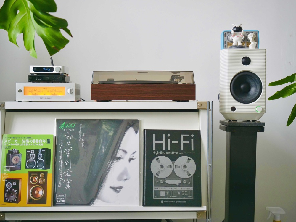 Gramofón ako súčasť domácej hi-fi zostavy s reproduktormi a vinylovou kolekciou.