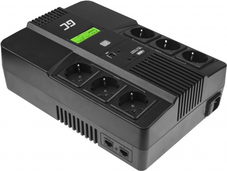 Na obrázku je záložný zdroj Green Cell AiO 800VA LCD zachytený šikmo zhora. Má robustné čierne telo so zaoblenými hranami a na hornej strane šesť elektrických zásuviek rozdelených do dvoch radov. Uprostred je malý zeleno podsvietený LCD displej, tlačidlo zapnutia, USB port a ďalšie ovládacie prvky, okolo ktorých sú výrazné chladiace rebrá. Na boku sú navyše vidieť dátové konektory a vetracie otvory.