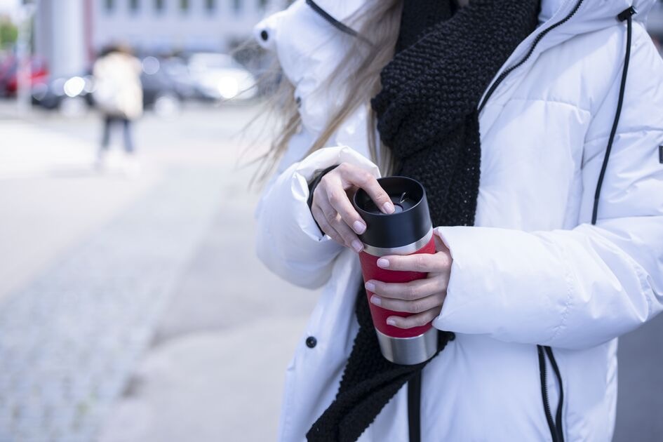 Termohrnček Tefal N2021510 Travel Mug Essential , 0,36 l tmavo šedá Žena v zimnej bunde otvára termohrnček Tefal N2021510 Travel Mug Essential