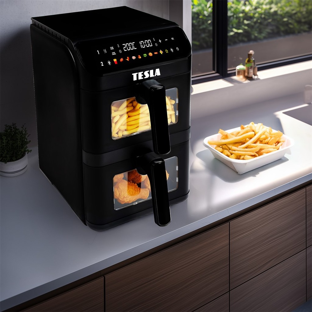Teplovzdušná fritéza Tesla AirCook DualZone Q670 XXL stojí na kuchynskej linke, vedľa nej je položená miska s hranilkami, v oboch nádobách fritézy sa chystá jedlo.