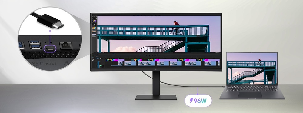 Veľký monitor pripojený k notebooku zobrazuje časovú os strihu videa. Detailný záber ukazuje pripojenie USB-C. Text označuje nabíjanie s výkonom 96 W.