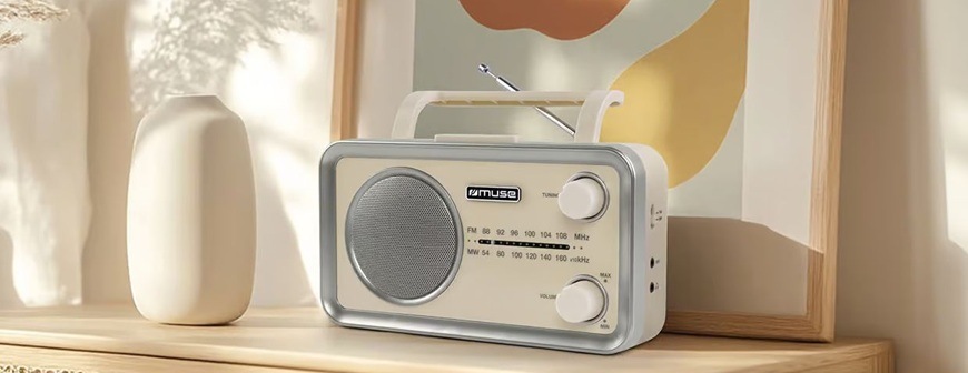 Rádioprijímač MUSE MF-060 SC je položený na drevenej skrini. Za ním sa nachádza moderný obraz a biela váza.