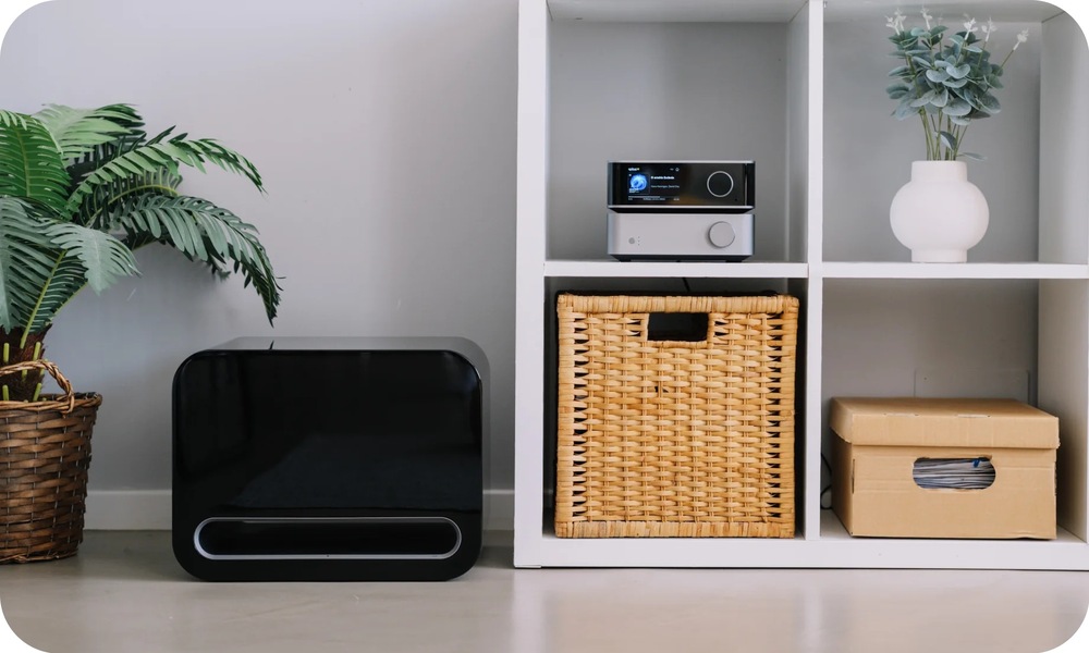 Subwoofer WiiM Sub Pro biely Subwoofer WiiM Sub Pro umiestnený vedľa televíznej zostavy v modernej obývacej izbe