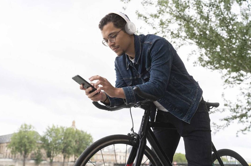 Slúchadlá JBL Tune 530BT biela Muž so slúchadlami na cyklistickom bicykli.