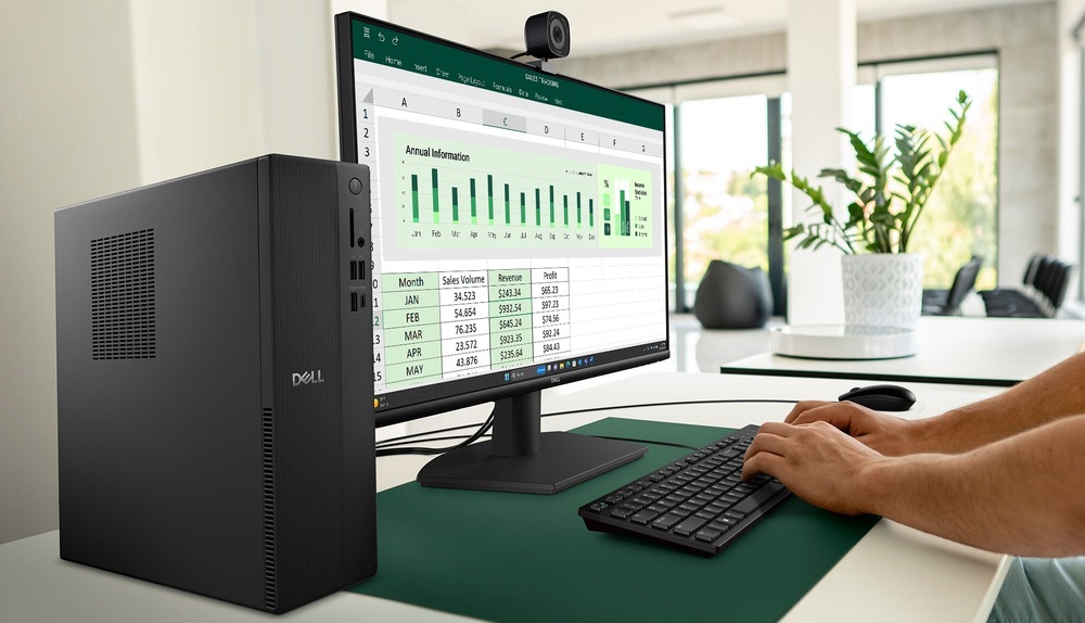 Stolný počítač Dell Pro Slim Essential QVS1260 čierny Osoba používa počítač s veľkým monitorom, na ktorom je zobrazená tabuľka Excel s rôznymi dátovými grafmi a diagramami. Pracovný priestor zahŕňa klávesnicu a myš, v pozadí je vidieť rastlina.