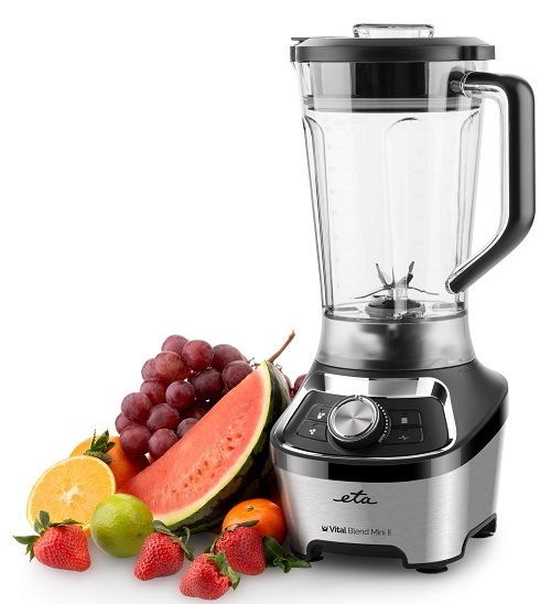 Stolný mixér ETA Vital Blend Mini II v nerezovom prevedení s tritánovou nádobou, obklopený čerstvým ovocím ako sú jahody, hrozno, melón a citrusy