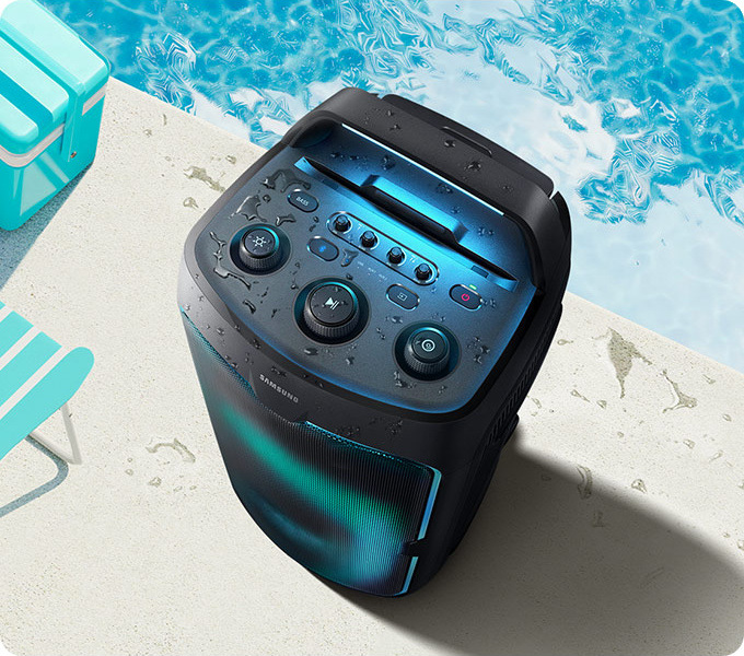 Párty reproduktor Samsung Sound Tower MX-ST50F čierny Reproduktor Samsung MX-ST50F stojí na okraji bazéna, na reproduktore sú kvapky vody