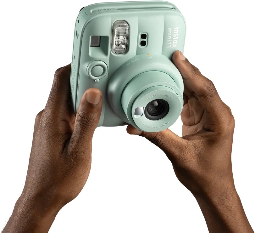 Instantný fotoaparát Fujifilm instax mini 13 ružový Detail rúk ovládajúcich instax mini 13 pomocou otočného objektívu