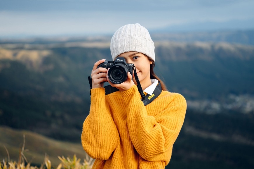 Digitálny fotoaparát Nikon Z 5II + 24-105 mm f/4-7.1 čierny Žena fotografujúca s použitím objektívu NIKKOR Z 24–105 mm f/4–7.1