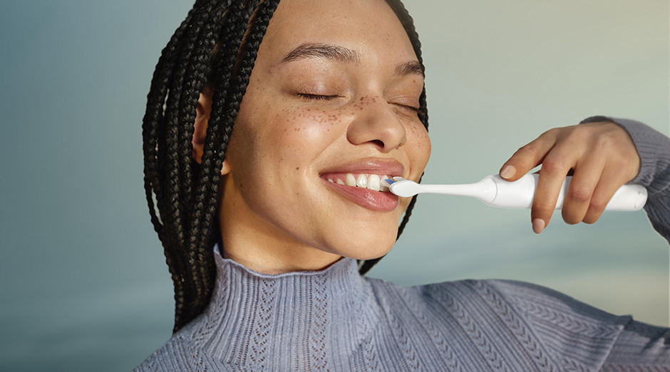 Žena si čistí biele zuby kefka sonicare
