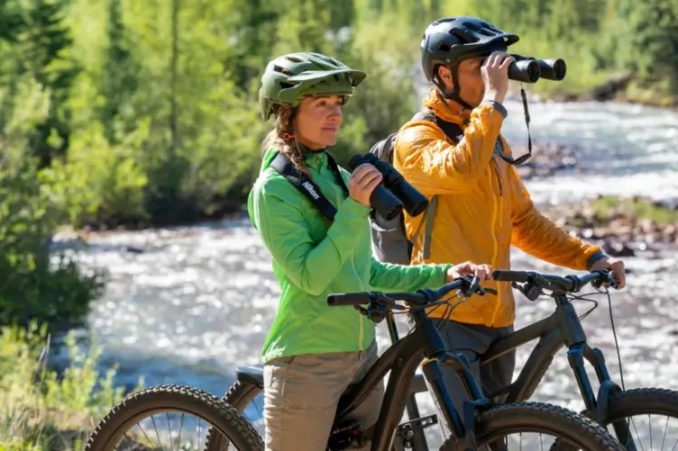 Ďalekohľad Nikon Action 12×50 čierny Pán s pani sú na výlete na bicykli, na chvíľu zastavili a každý sa kochá s pomocou ďalekohľadu Nikon Action 12×50 krásnou prírodou.