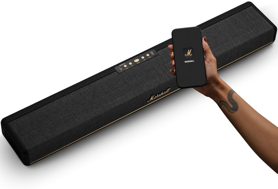 Ruka so smartfónom s aplikáciou Marshall a soundbar Heston 60″ width=