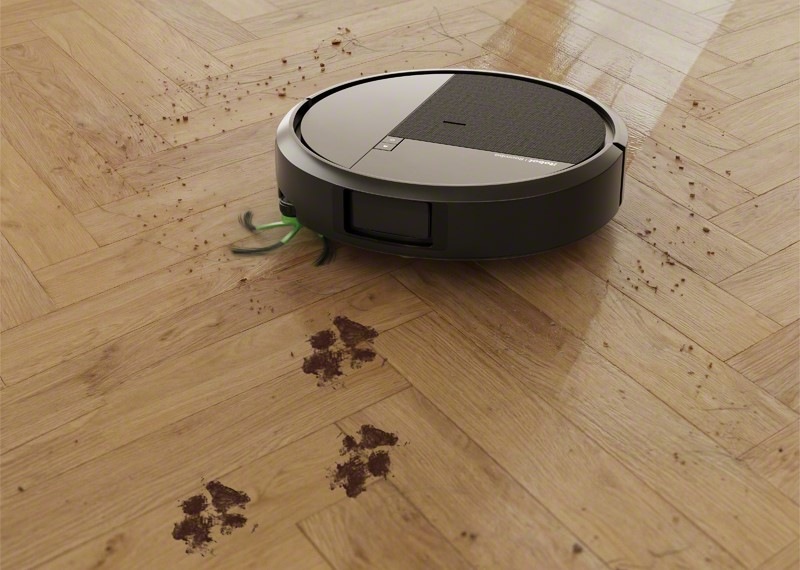 Robotický vysávač iRobot Roomba Plus 415 Combo na drevenej podlahe mopuje zaschnuté packy od psíka.
