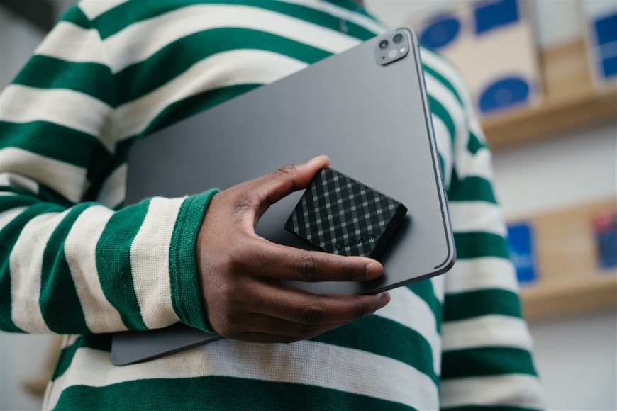 SSD externý Verbatim Store 'n' Go Mini Diamond 1TB USB 3.2 Gen 2 čierny Detail osoby nesúcej v jednej ruke notebook a kompaktný SSD Verbatim Store 'n' Go Mini Diamond