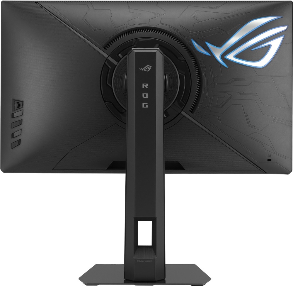 Herný monitor Asus ROG Strix XG248QSG Ace čierny Na obrázku je zadná strana herného monitora ASUS ROG Strix. Monitor má čierne telo s výrazným herným vzorom a veľkým podsvieteným logom ROG v pravej časti. Uprostred je kruhový kĺb na natočenie monitora a pevný výškovo nastaviteľný stojan s nápisom ROG. V spodnej časti stojana je otvor na vedenie káblov a dole plochá hranatá základňa. Vľavo na zadnej strane sú vidieť ovládacie tlačidlá monitora.