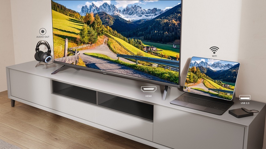 Televízor Hisense 40A4S na skrinke sa nachádza Televízia Hisense 40A4S a vedľa nej notebook a slúchadlá