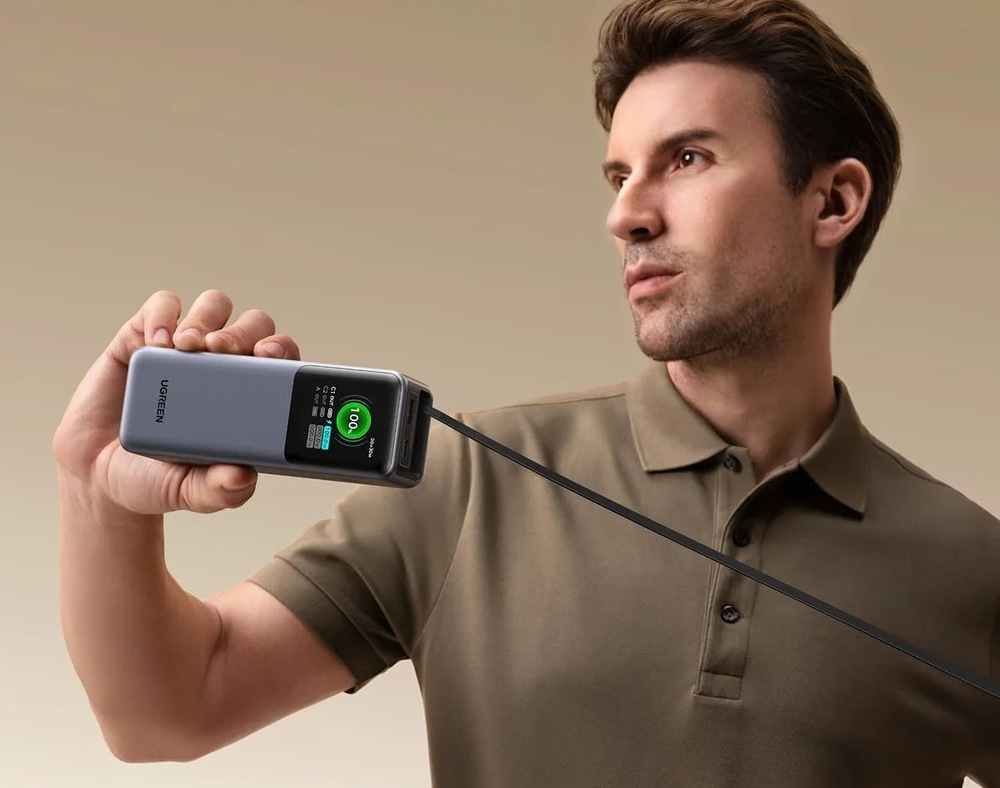 Powerbank UGREEN 20000 mAh, 165W sivý Muž drží v ruke powerbanku s integrovaným káblom