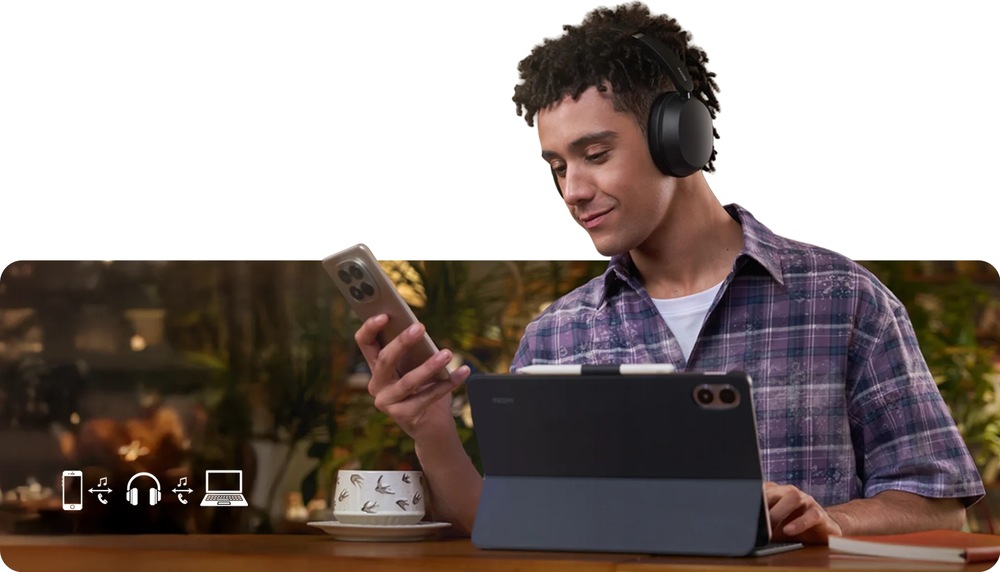 Slúchadlá Xiaomi REDMI Headphones Neo Obsidian čierna Muž so slúchadlami Xiaomi REDMI Headphones Neo má pred sebou tablet av ruke smartphone