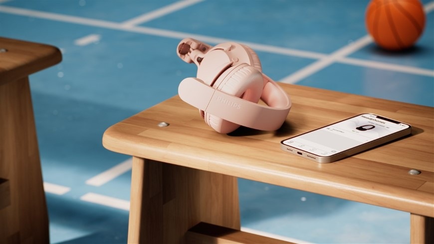 Zložené slúchadlá Philips položené na lavici vedľa smartfónu