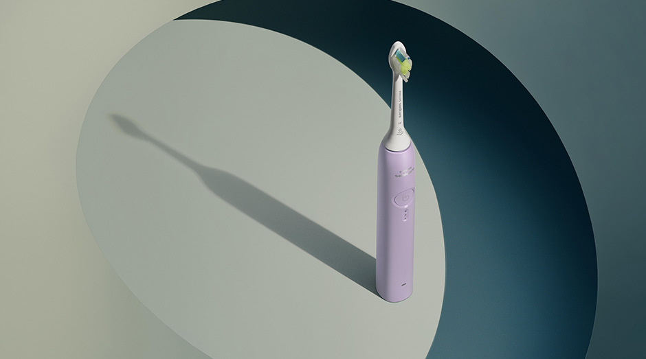 Zubná kefka Philips Sonicare 3100 HX4033/27 fialová Stojaca kefka Philips HX4033/27 Sonicare 3100 a za ňou tieň