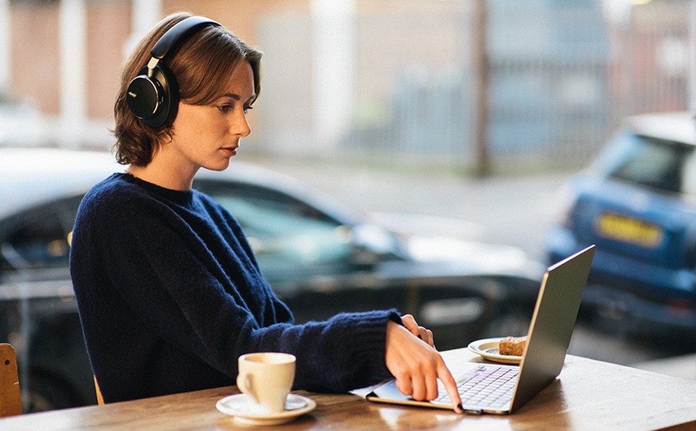 Slúchadlá AKG N9 Hybrid biela Žena pracujúca na notebooku v kaviarni má na hlave slúchadlá Anker soundcore AKG N9 Hybrid