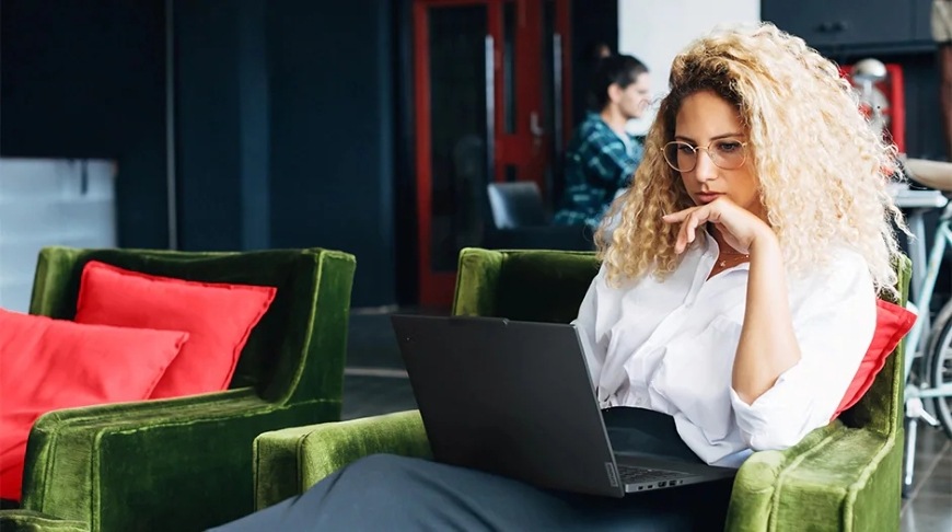 Žena pracujúca na notebooku Lenovo ThinkPad T14 Gen 6″ width=