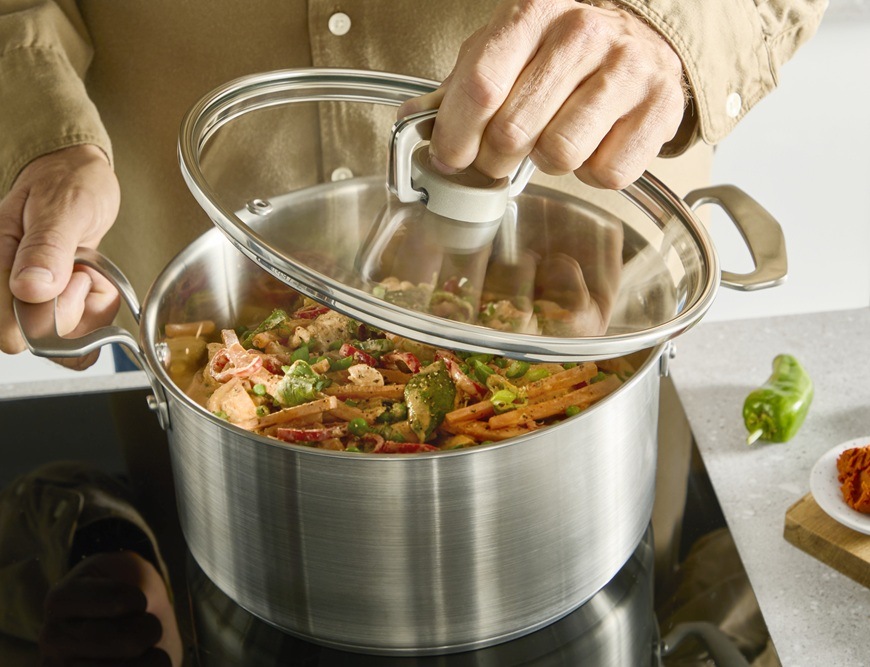Hrniec s pokrievkou Tefal Extreme E5294304, 18 cm nerez Muž jednou rukou zdvíha pokrievku z kastróla Tefal.