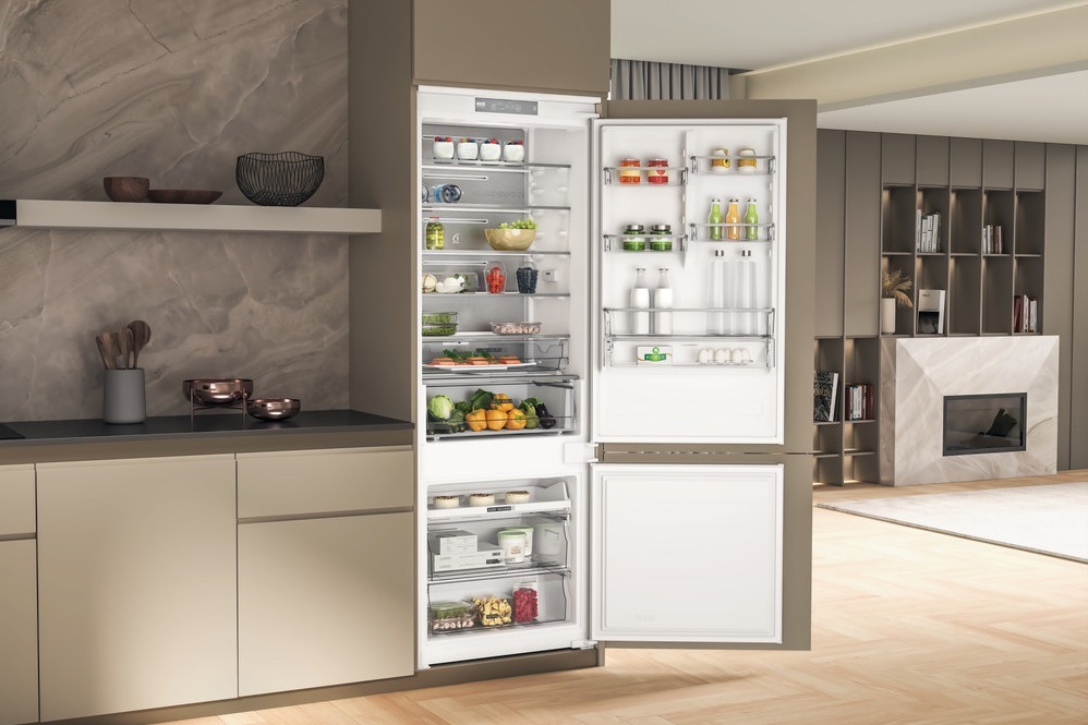 Interiér modernej domácnosti s kombinovanou chladničkou Chladnička kombinovaná Whirlpool WH SP70 T121, NoFrost vstavaná, pohľad do obývacej izby a do otvorenej chladničky