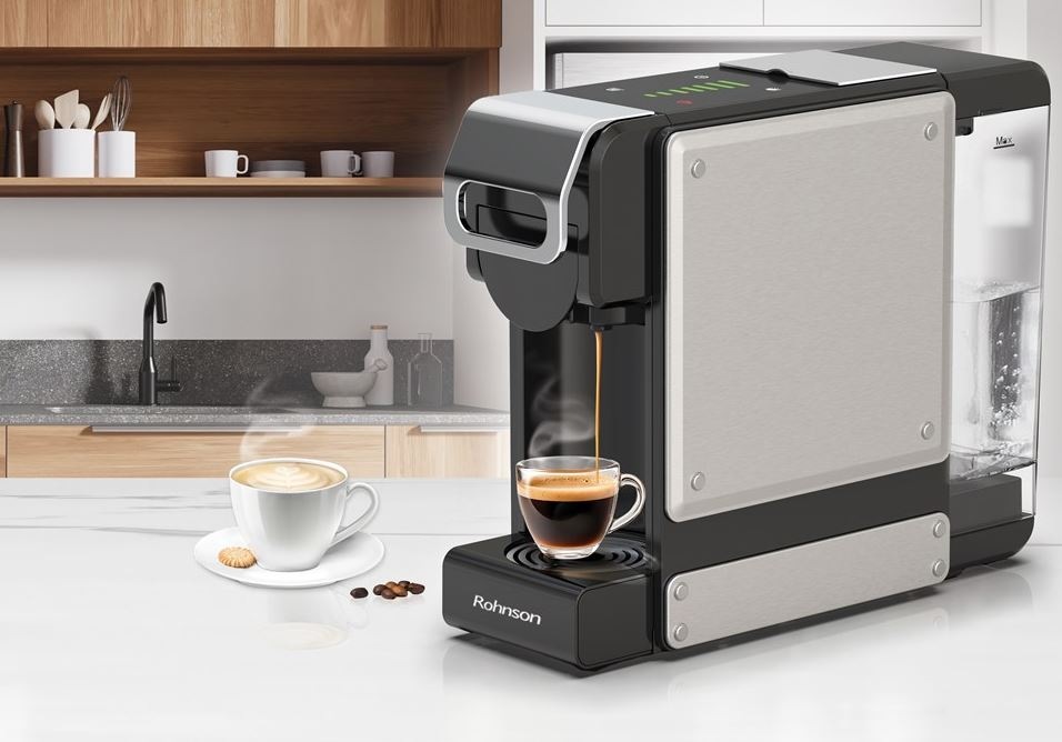 kávovar Rohnson R-98054, ktorý práve pripravuje espresso. Vedľa stojí už pripravené cappuccino. Kávovar sa nachádza v dreveno-bielej kuchyni.