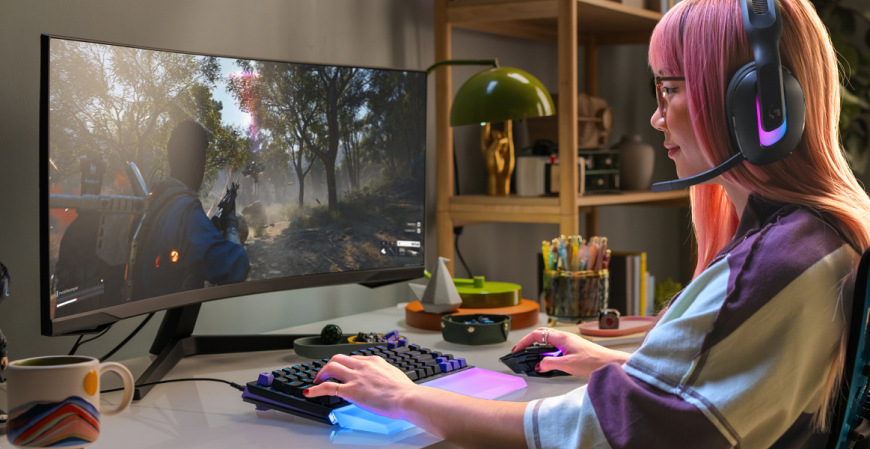 Klávesnica Logitech G512 X 75, US INTL layout, Tactile čierna Hráčka používajúca Logitech G512 X 75 pri hraní akčnej hry na širokouhlom monitore