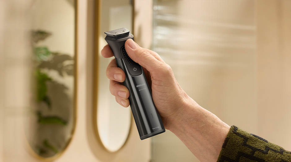 Zastrihávač multifunkčný Philips Series 9000 MG9690/30 + Philips OneBlade na tvár čierny Muž drží v ruke zastrihávač