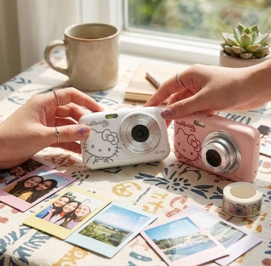 Digitálny fotoaparát Yashica x Hello Kitty DZ-100 biely Ruky držia fotoaparáty Yashica x Hello Kitty DZ-100
