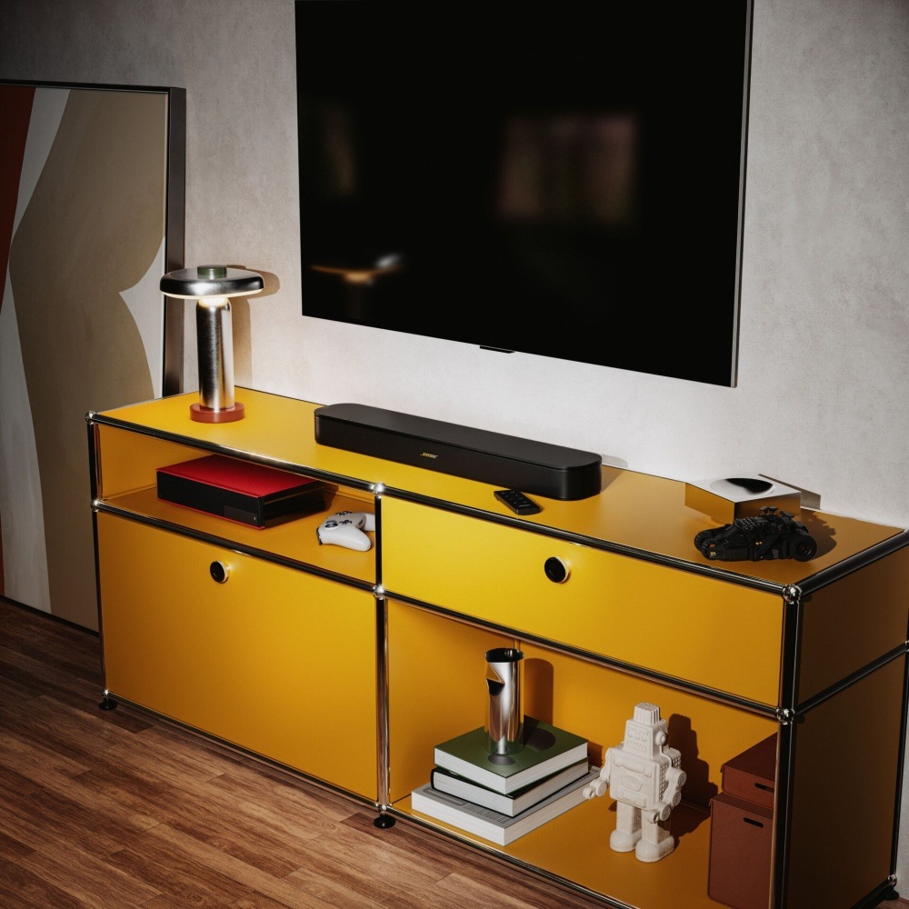 Soundbar Bose TV Speaker 2nd.Gen. čierny Soundbar Bose TV Speaker na žltej komode pod zavesenou televíziou v obývacej izbe.