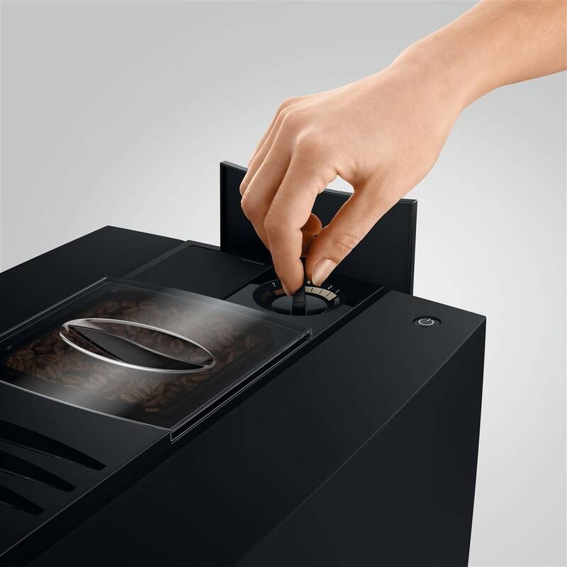 Ruka nastavuje hrubosť mletia na mlecom mechanizmu kávovaru Jura