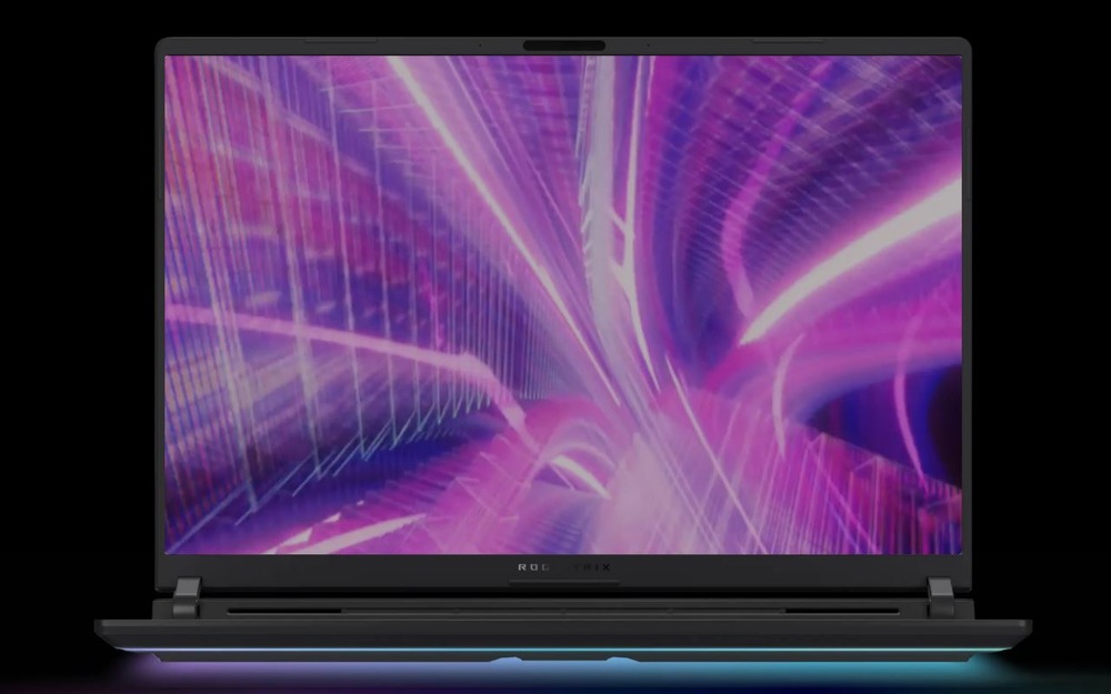 Notebook s výrazným abstraktným digitálnym dizajnom v ružovej a fialovej farbe na obrazovke pred tmavým pozadím.