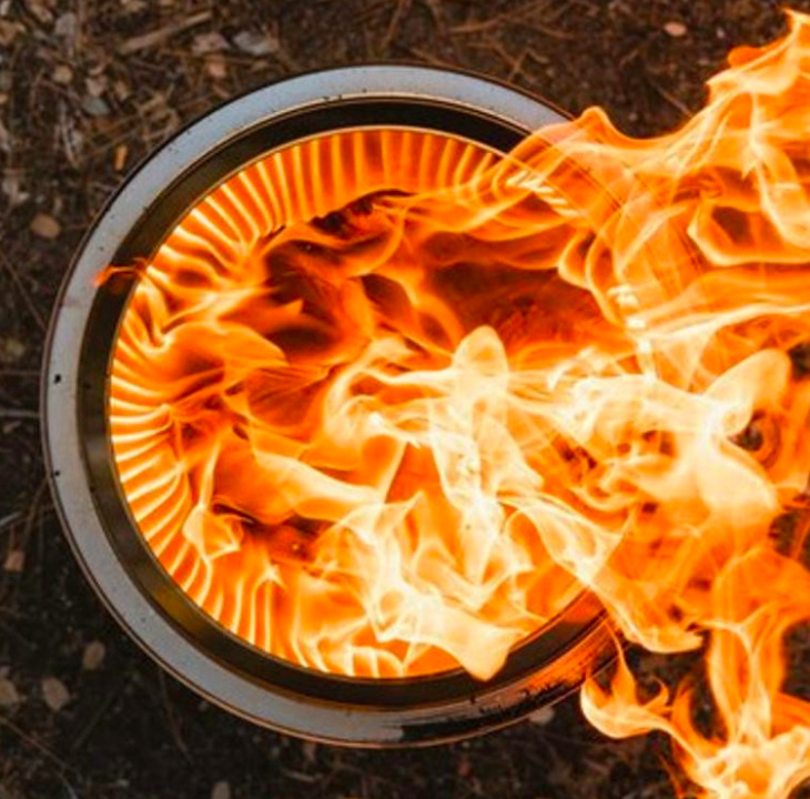 Detail hornej časti ohniska Solo Stove Bonfire + stand 2.0 s plameňmi a vetracími otvormi