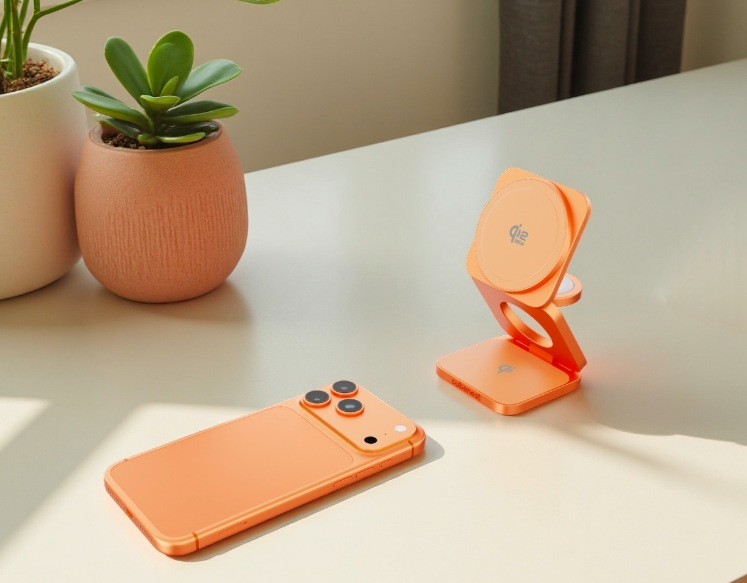 Bezdrôtová nabíjačka Cubenest SQ312 Ultra Qi2.2 3v1 s MagSafe oranžová Zložená bezdrôtová nabíjačka Cubenest SQ312 Ultra a iPhone v rovnakej farbe položenej na pracovnom stole