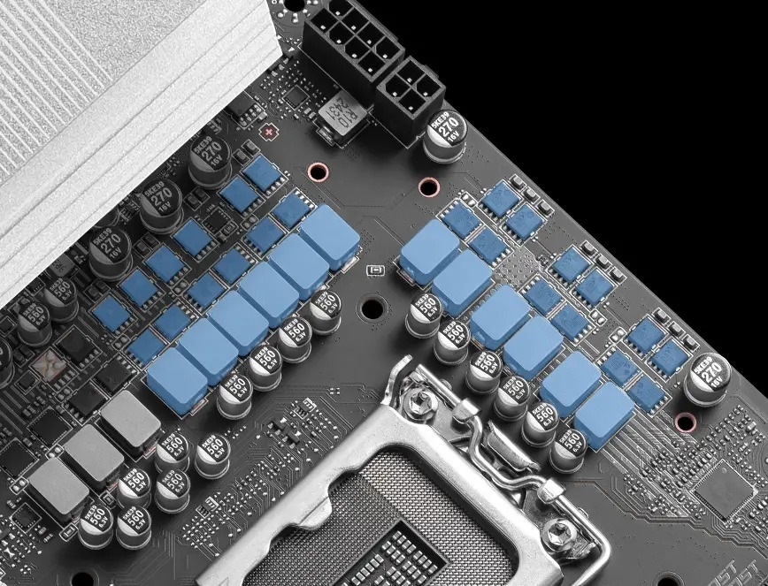 Základná doska MSI PRO B860M-A WIFI Detail počítačovej základnej dosky s päticou pre procesor obklopenou radmi kondenzátorov a modrými chladičmi.