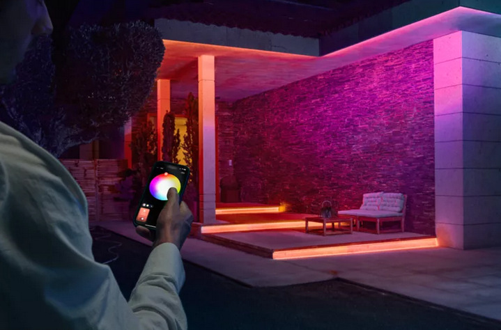 LED pásik Philips Hue LED pásik Philips Hue Flux outdoor strip light EU, 5 m + Senzor Philips Hue Outdoor Muž ovládajúci LED pásik na terase.