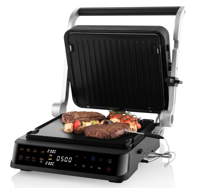 Otvorený kontaktný gril ETA DigiChef s hovädzími steakmi, špízmi a paradajkami na hladkej grilovacej doske a zapojenou teplotnou sondou