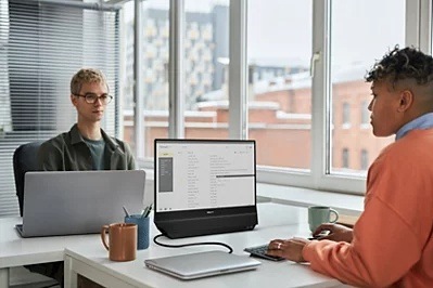 Monitor Philips 24B2D5300/00 čierny Žena a muž v zdieľanej kancelárii pracujú každé na jednej strane duálnej obrazovky Philips
