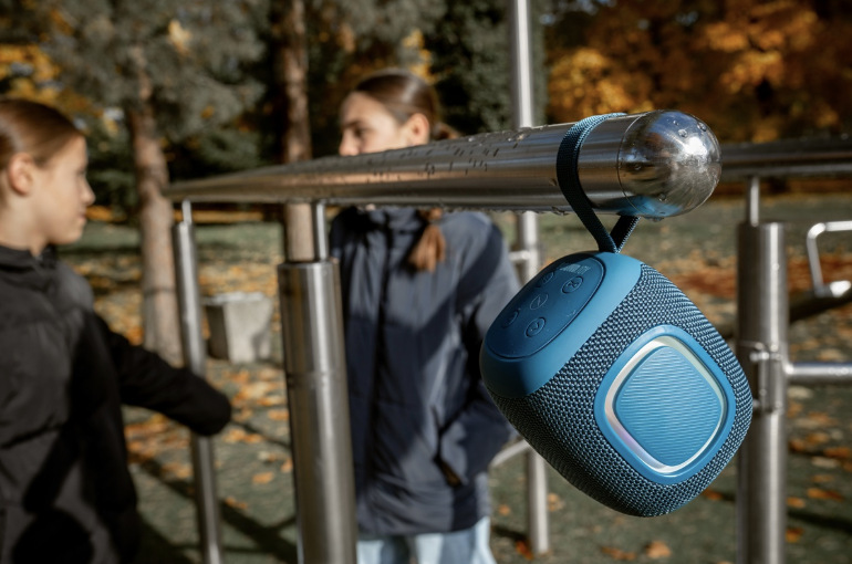 Prenosný reproduktor Concept SoundJoy BR5012 modrý Concept SoundJoy BR5012 zavesený pútkom na kovovom zábradlí počas vonkajšieho použitia