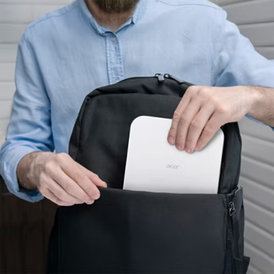 Projektor Acer PD1520s biely Muž vkladá prenosný projektor Acer PD1520s do batohu