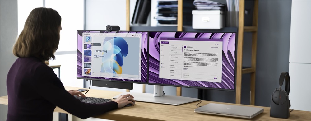 Dva šedé monitory Dell Pro P 24 P2426HE umiestnené vedľa seba na pracovnom stole. Zostavu dopĺňa webkamera, soundbar, klávesnica, myš, notebook a náhlavná súprava.