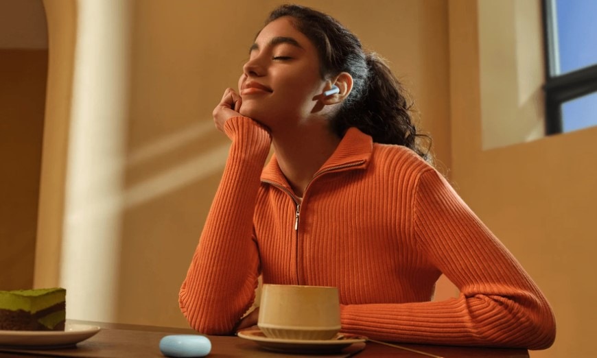 Slúchadlá Xiaomi REDMI Buds 8 Active čierna Relaxujúca žena s dezertom a šálkou kávy má v uchu slúchadlo REDMI Buds 8 Active
