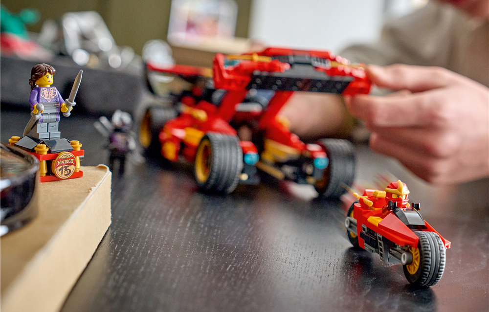 Stavebnica LEGO® NINJAGO® 71867 Kaiův červený bourák: 15 let NINJAGO Súčasťou sú tri minifigúrky LEGO vrátane Kaie, generála Kryptora a novej majsterky tieňov, ktorú môžete vystaviť na podstavci s výročnou mincou.