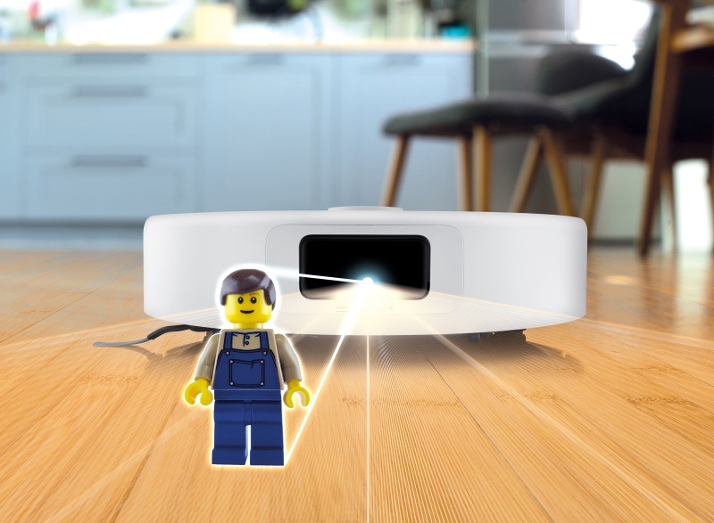 Robotický vysávač ETA Master Aqua Pro pri práci detekujúci lego figúrku na podlahe pomocou 3D scanu
