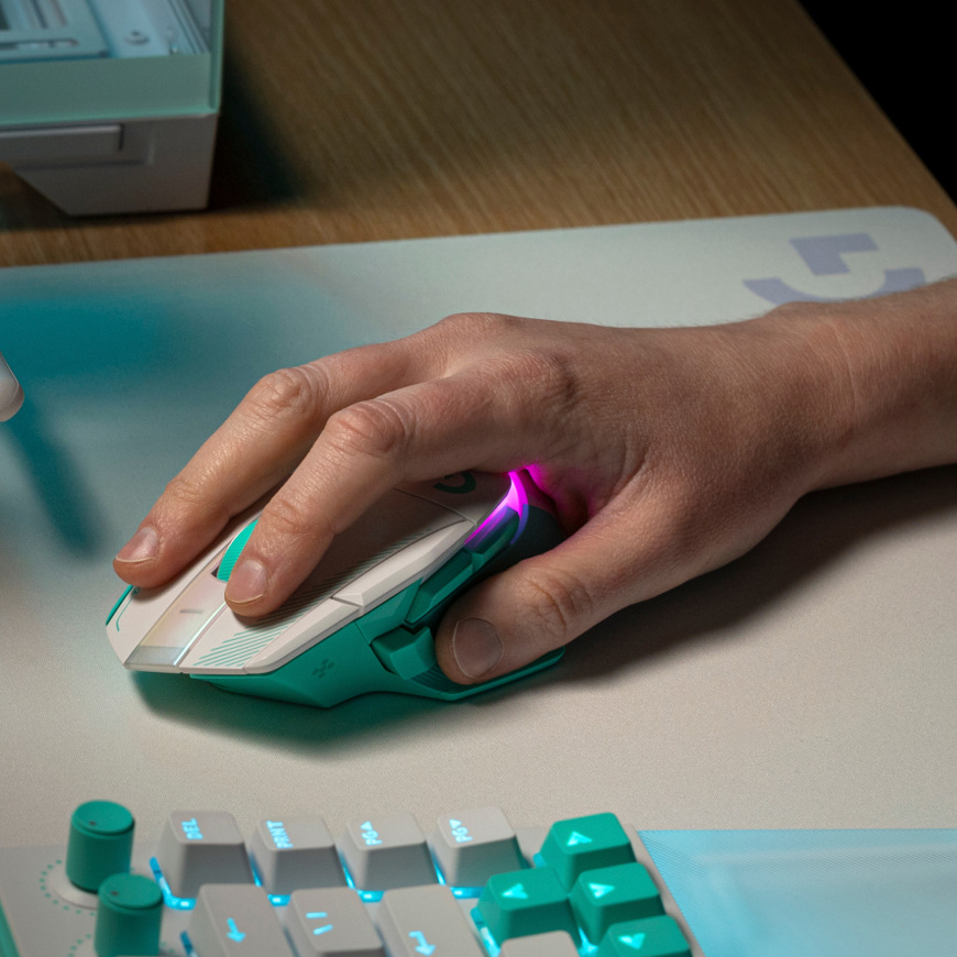 Ruka ovládajúca myš Logitech G502 X Plus na podložke vedľa klávesnice