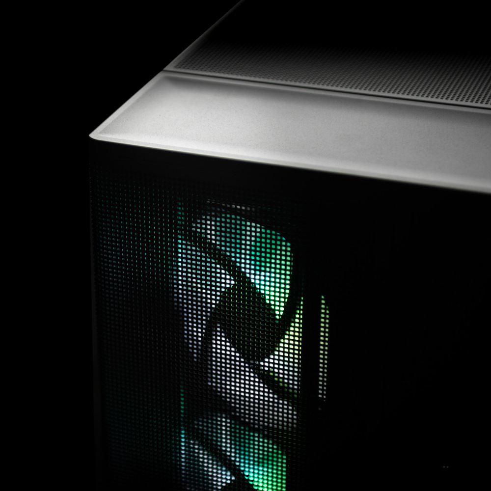 Herný počítač Lynx Ultimate Ryzen 7 čierny Detailný záber na počítačovú skriňu s predným panelom zo sieťoviny a viditeľným ventilátorom. Ventilátor svieti zelenými a bielymi LED diódami a vytvára tak moderný, technologicky inšpirovaný dojem.